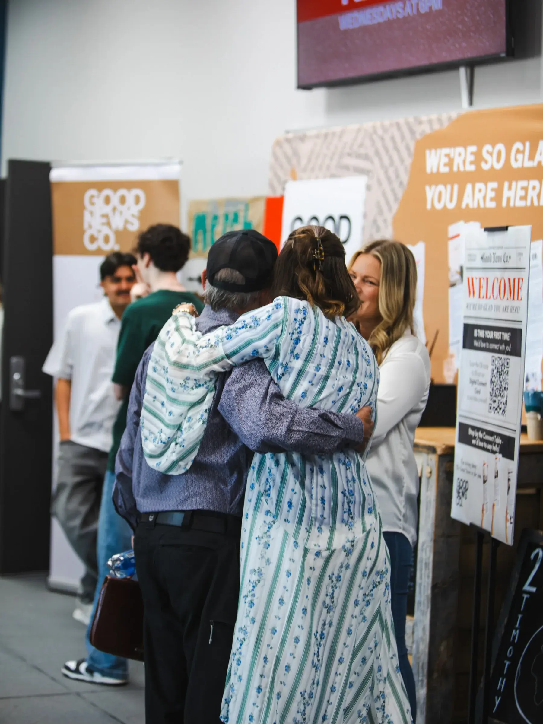 Friends embracing at a Good News Co. gathering.