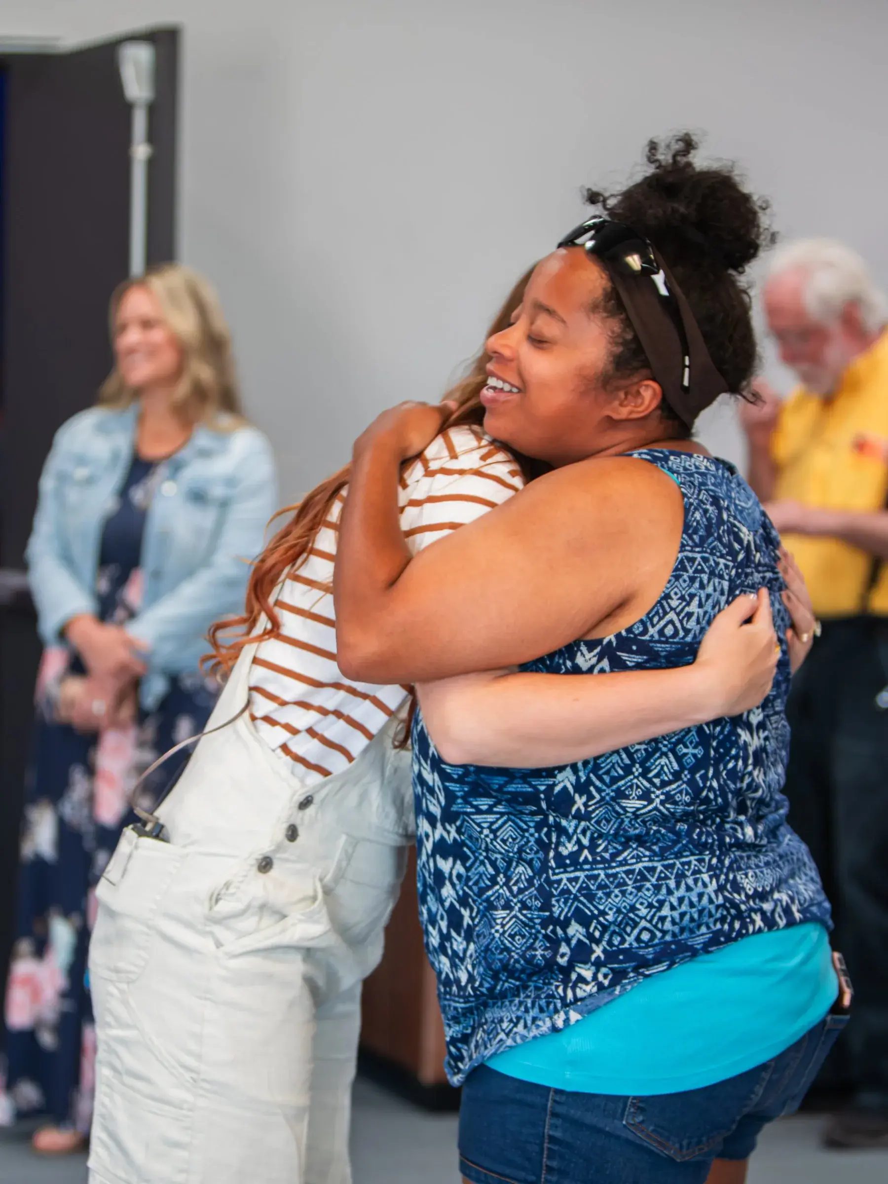 Friends sharing a joyful welcome at Good News Co.