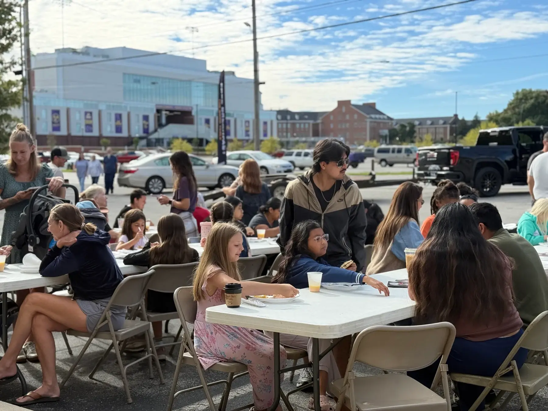 Neighbors and families sharing breakfast around outdoor tables at The Good Table.