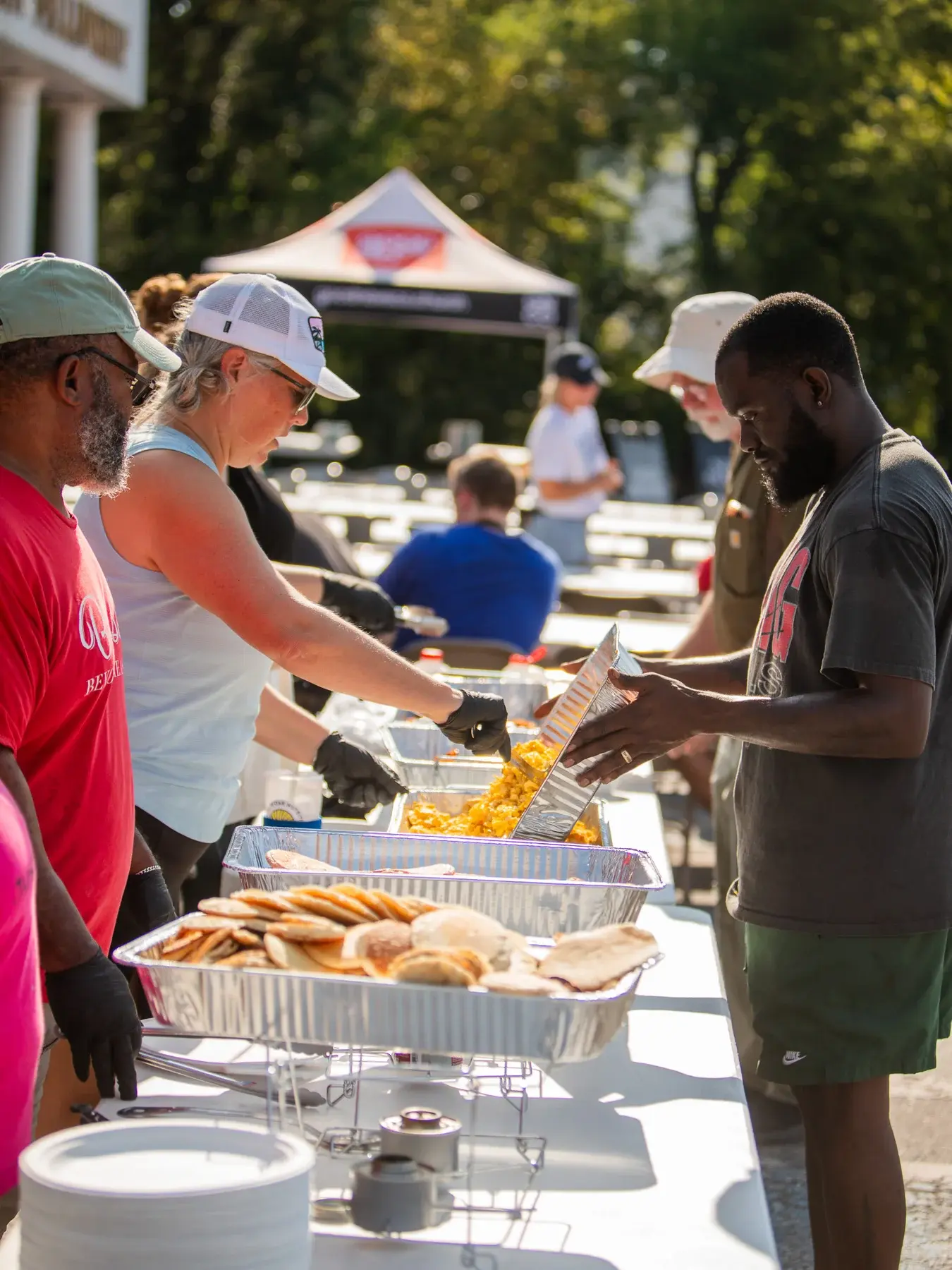 Volunteers working together to prepare pancakes and eggs for their neighbors.