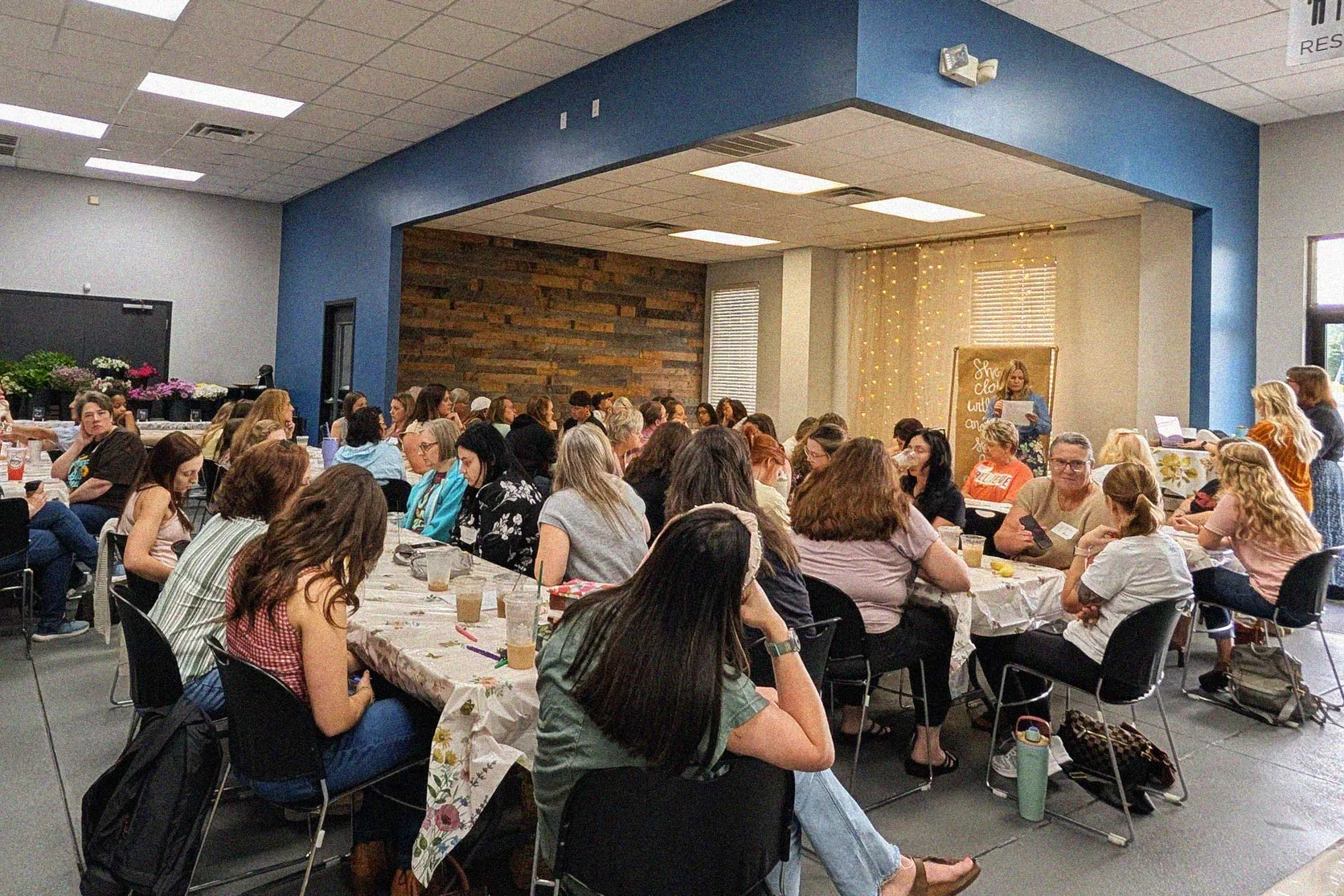 Women gathered around tables at Good News Co.